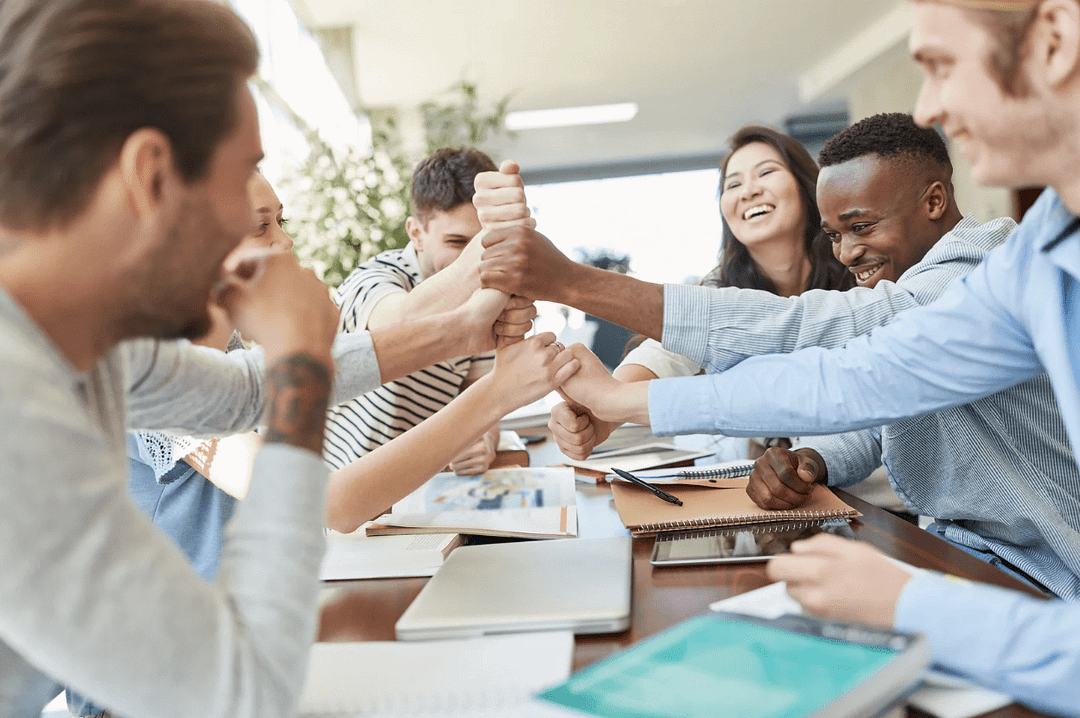 un groupe de collaborateur se serrant la main lors d'une réunion professionnelle